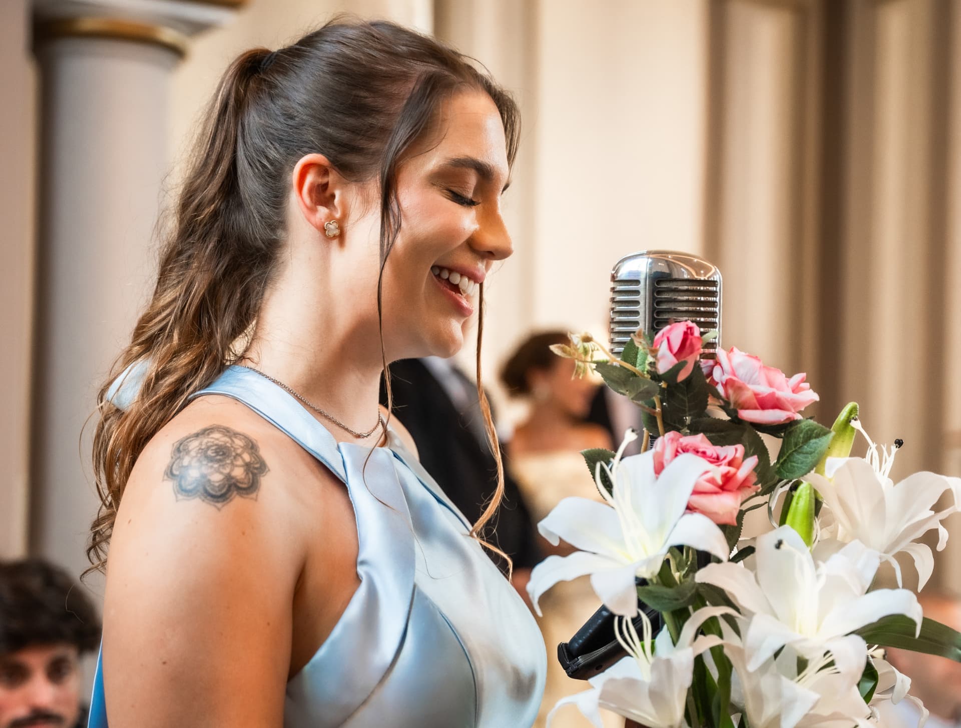 Julia Jorge cantando ao microfone em uma cerimônia